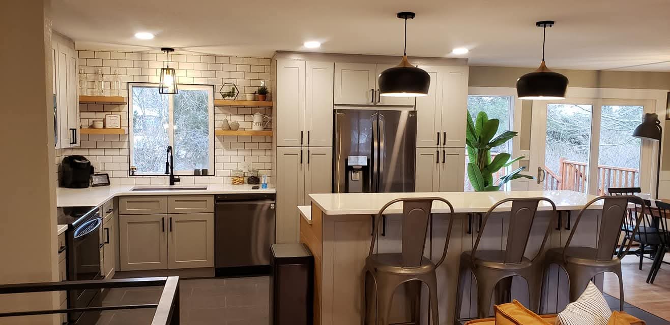 Open concept kitchen remodel in Fort Collins with grey shaker cabinets, subway tile backsplash, and a view into the connected dining area