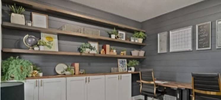 Custom floating shelves and built-in cabinetry on a shiplap accent wall in a Windsor, Colorado home office